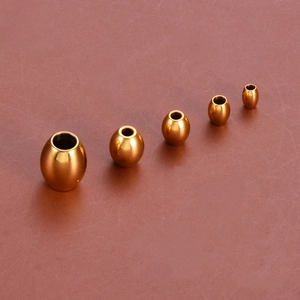 Vue macro de cinq tailles de perles ovales dorées en acier inoxydable pour bijoux DIY