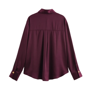 Back view of a deep purple satin blouse featuring center pleats and gold cuff buttons
