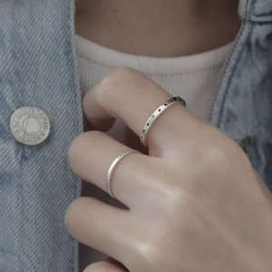 Close-up of minimalist 925 silver star ring and twisted band on a model's finger