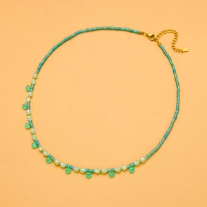 Detailed view of handmade beaded necklace with green stone charms and gold lobster clasp