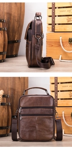 Detail view of genuine leather messenger bag with grain texture and metallic zippers