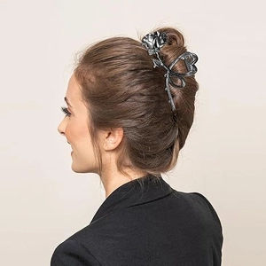 Detail of a gunmetal rose flower claw clip styling a hair bun for a vintage French look