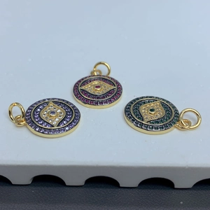 Three gold evil eye pendants with zircon in purple, red, and green circular designs