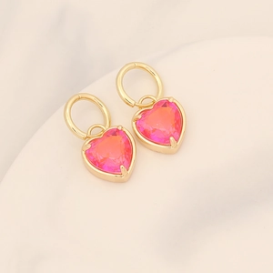 Close-up of heart-shaped gradient pink crystal earrings with 18K gold-plated hoops