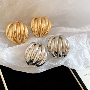 Detailed view of layered rope-texture spherical stud earrings in gold and silver finish