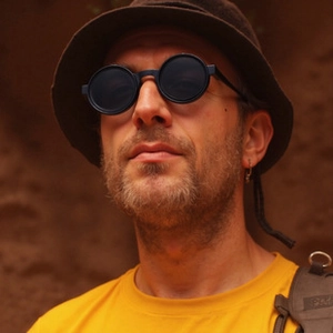 Close-up of retro round rimless sunglasses with metal hollow temples on a male model