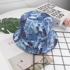 Detailed close-up of blue and white floral bucket hat on a white marble background