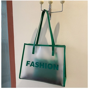 Detail of green semi-transparent frosted PVC tote bag with FASHION lettering