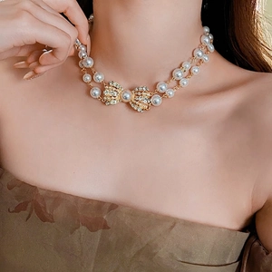 Vintage double-layer pearl necklace with sparkling diamond-encrusted bow pendant