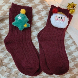 Plush Christmas socks for kids featuring a reindeer and Santa Claus design in red