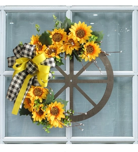 Detail of wooden wheel wreath with sunflowers and black-and-white checkered bow ornament