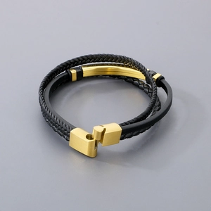 Close-up of multilayer black leather braid bracelet with a polished gold magnetic clasp