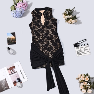 Abito in pizzo nero con scollo a goccia e grande fiocco decorativo in primo piano
