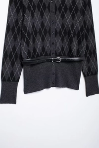 Close-up of argyle knit cardigan with button-front closure and slim black waist belt
