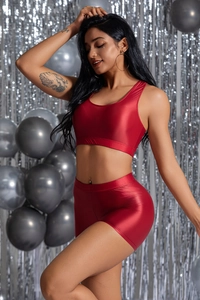 Dettaglio degli shorts da yoga rossi metallizzati e del crop top con scollo a U