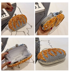 Detail view of silver clutch bag with orange sequins, metal frame, and chain strap