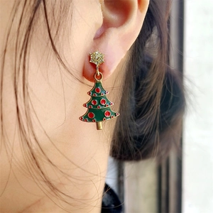 Pink Christmas tree star earrings with green enamel and rhinestones on a female model