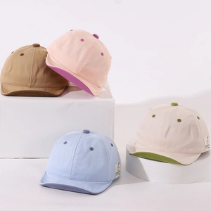 Group shot of colorful cotton baby baseball caps with soft brims and Good Luck labels
