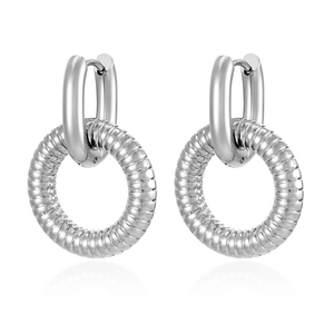 Detailed view of silver textured hoop earrings with oval drop pendants on white background