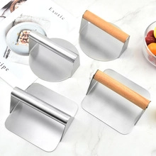 Flat lay of stainless steel round and square meat presses with wood and metal handles