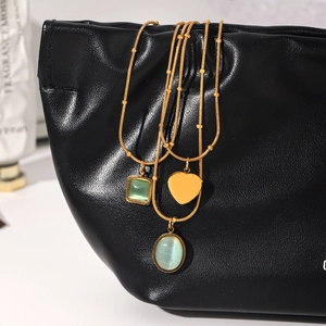 Close-up of gold stainless steel necklaces with blue and green cat's eye stone pendants