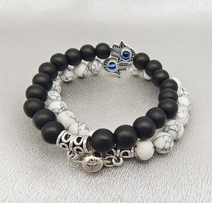 Detail view of magnetic couple bracelets with Hamsa Hand charms and natural stone beads