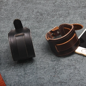 Retro punk style wide leather bracelets in black and brown with belt buckle closure