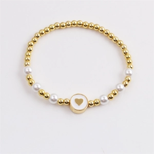 Elegant gold-plated copper bead and pearl bracelet featuring a white heart charm pendant
