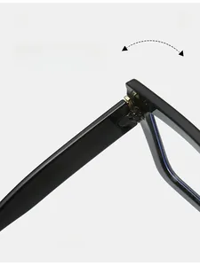 Dettagli delle cerniere in metallo dorato su eleganti occhiali quadrati neri oversize