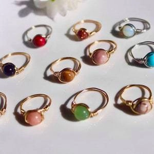 Macro shot of assorted handmade wire-wrapped rings with colorful stone beads in a collection