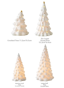 Detail view of mini white ceramic Christmas trees with warm LED light and gold dots