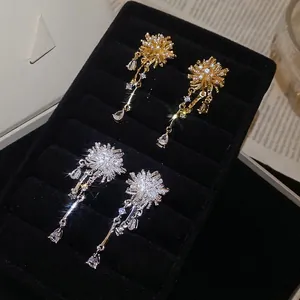 Elegant gold and silver tassel earrings with pearls and zircon star studs in a black box