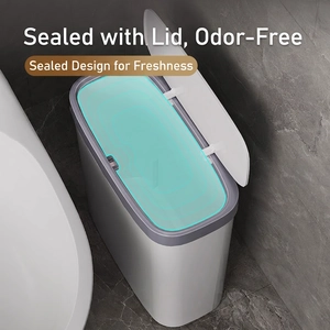 Slim white bathroom trash can with grey sealed lid placed in a modern marble corner