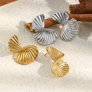 Detailed view of twisted shell texture on 18K gold and silver plated fan-shaped earrings