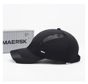 Detail of black quick-dry mesh cap featuring breathable side panels and white rubber patch