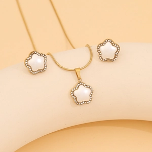 Detail view of gold flower jewelry set featuring white mother-of-pearl and micro-inlaid stones