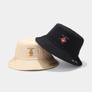Embroidered cotton bucket hats with carrot and tomato graphics in beige and black