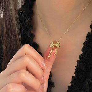 Elegant gold bow pendant necklace for women with a vintage finish and delicate chain