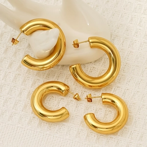 Polished gold plated C-shaped hoop earrings in two sizes on minimalist display