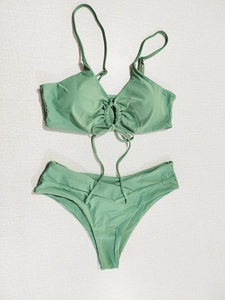 Detailed view of sage green bikini with drawstring ruching and halter bow tie