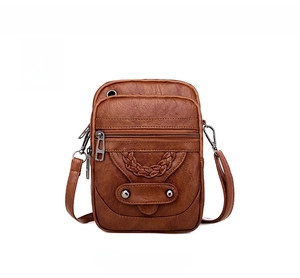Detailed front view of brown vintage textured crossbody bag with woven design and metal zippers