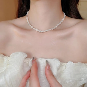 Detailed view of elegant triple-layered pearl choker necklace on a model neck