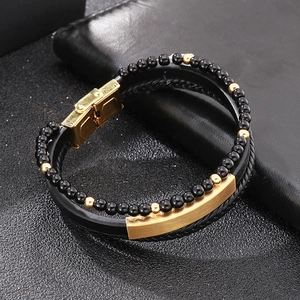 Detail of multi-layer men's bracelet with gold magnetic clasp and black beaded texture