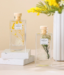 Close-up of reed diffuser with preserved yellow flowers and white stone base