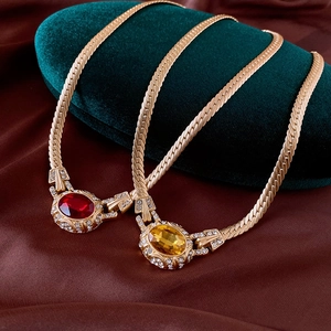 Nahaufnahme vintage Goldketten mit Rubin- und Citrin-Edelsteinen auf Samt
