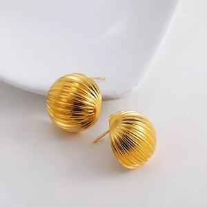 Close-up of 18K gold textured ball earrings with vertical striped patterns on a white tray