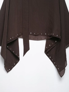 Detail of dark brown cape top featuring silver rivet studs and fine wrinkled texture