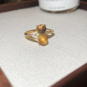 Macro shot of gold-plated ring featuring tiger eye stones and cubic zirconia inlay