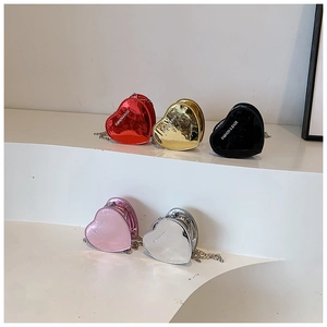 Mini heart-shaped chain bags in red gold black pink and silver on white steps