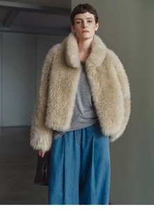 Close-up of beige faux fur cashmere vest showing plush texture and high collar detail